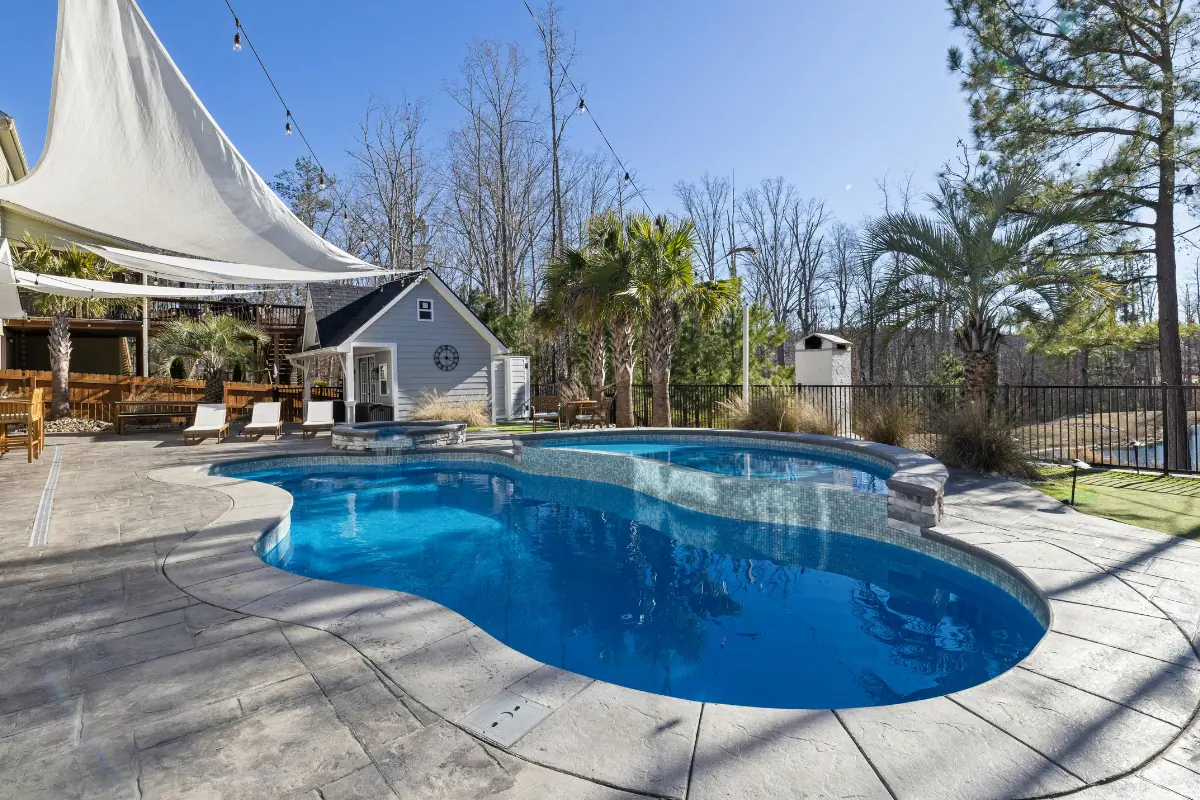 Stamped concrete pool deck wrapping a freeform pool in the Western NC mountains - The Asheville Concrete Company